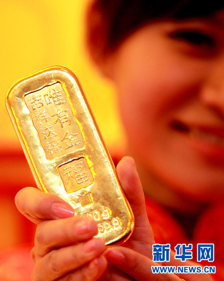 一位礼仪小姐展示一款1000克的“工银金行家―唯有金・礼赞金条”。